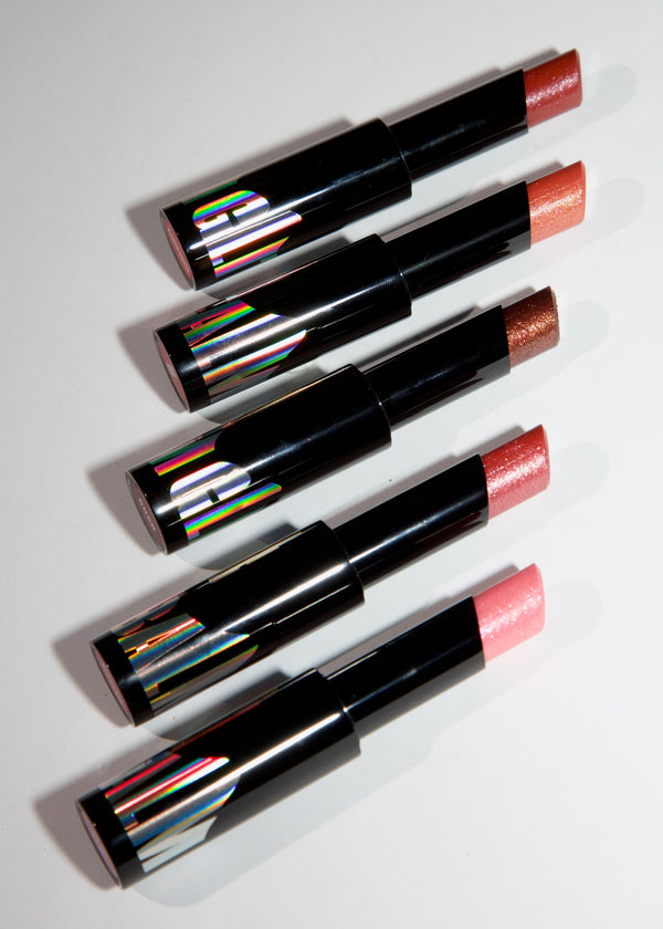Five lipsticks in black tubes arranged diagonally on a white background, showing different lipstick shades including pink, orange, and brown, with holographic caps.